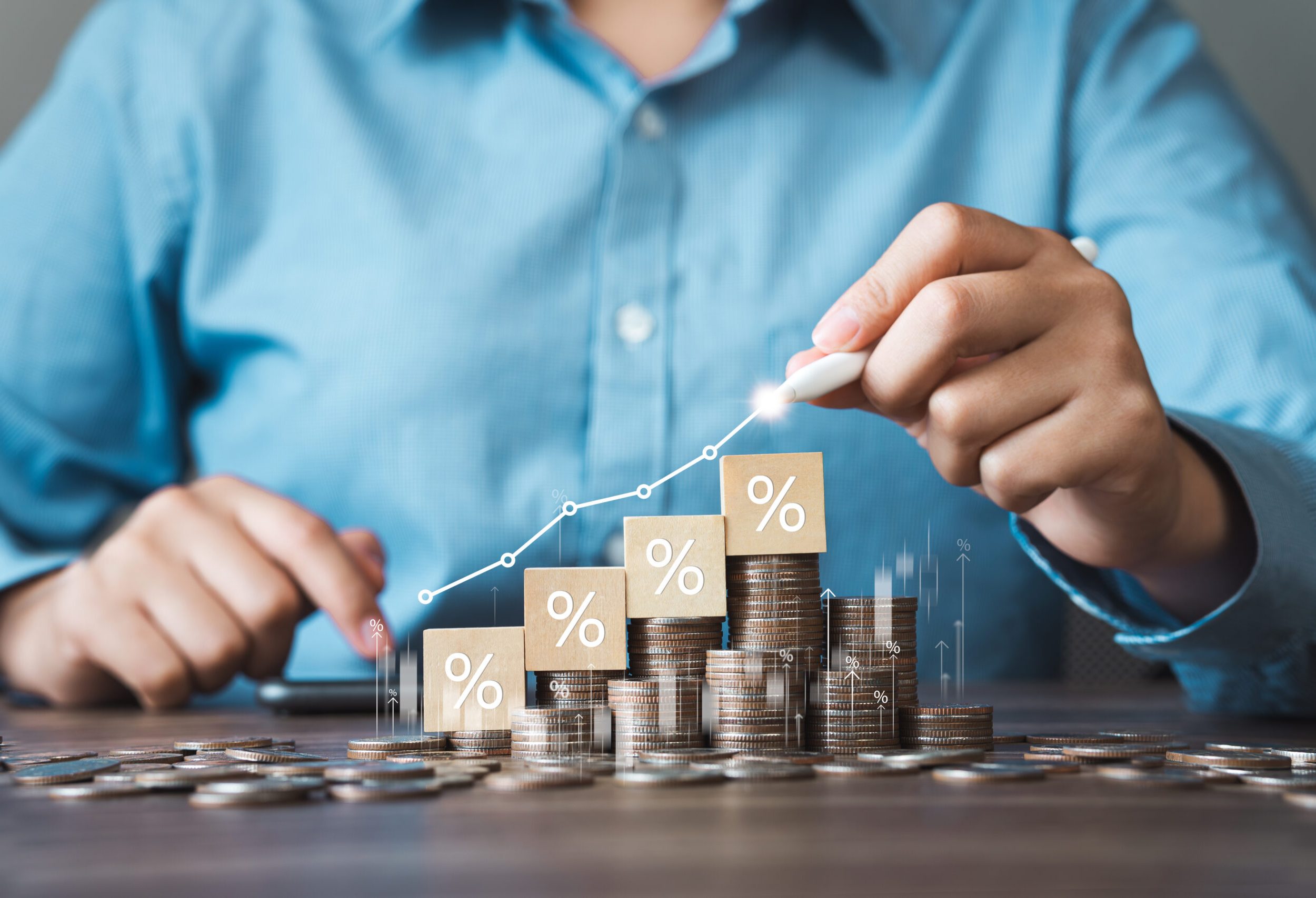 Businessman is calculating income and percentage return on investment. Concepts of interest rates and dividends Stack of coins with trading charts in financial and business stock growth trends.